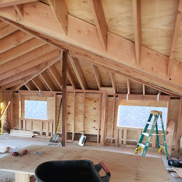 Interior of a room with a wooden ceiling and a ladder.