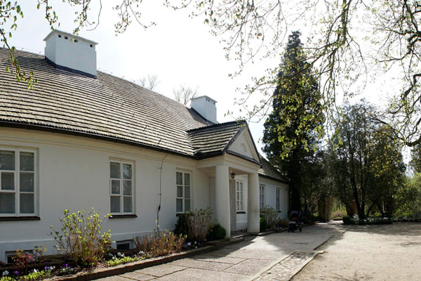 White house with black roof and path leading to front door.